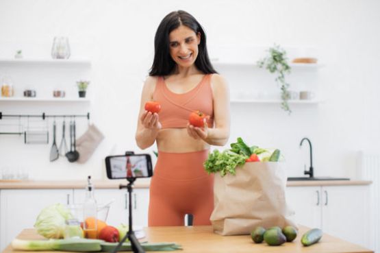 Mujer deportista grabando consejos nutricionales con teléfono