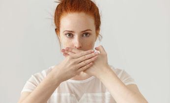 portrait-serious-young-ginger-european-woman-covering-mouth-with-both-hands-keeping-secret-freckled-redhead-female-blouse-doesn-t-want-spread-rumors-some-confidential-information copia