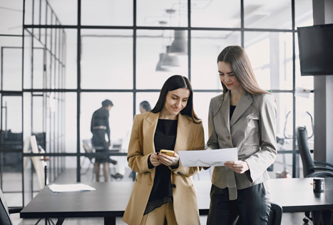 Mujeres de negocios hablando cerca del escritorio