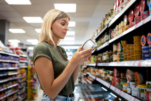 Mujer revisando una etiqueta de un producto en un supermercado