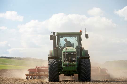 Agricultor en el tractor trabajando en el campo