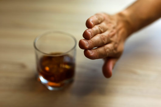 Persona rechazando una copa de alcohol
