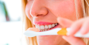 Persona cepillándose los dientes, promoviendo la salud bucodental
